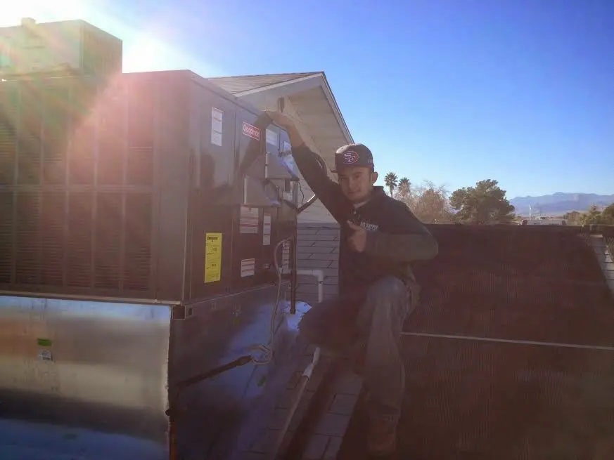 HVAC technician performing HVAC Inspection on a rooftop unit in Saco